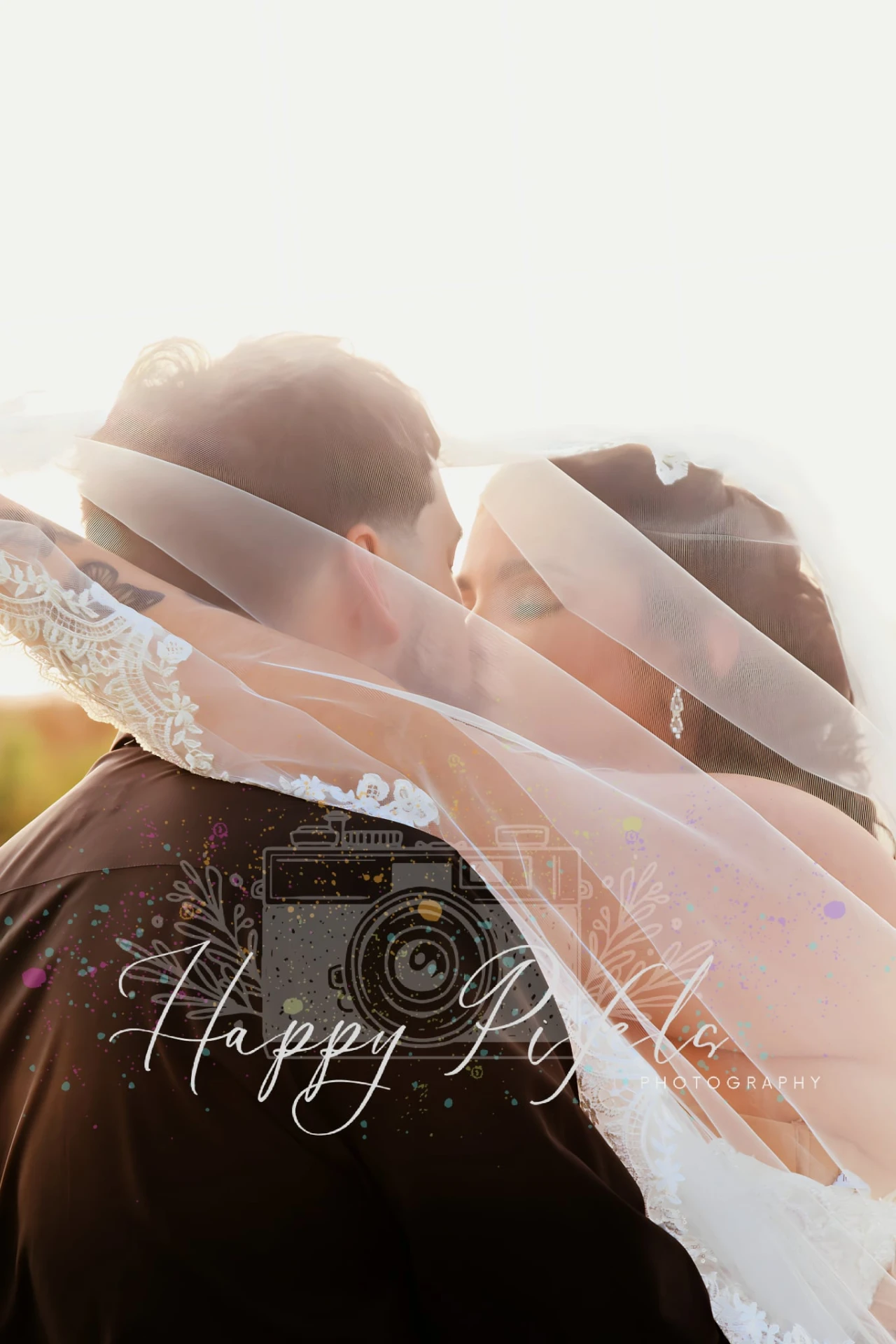 Bride and groom beneath the veil at sunset